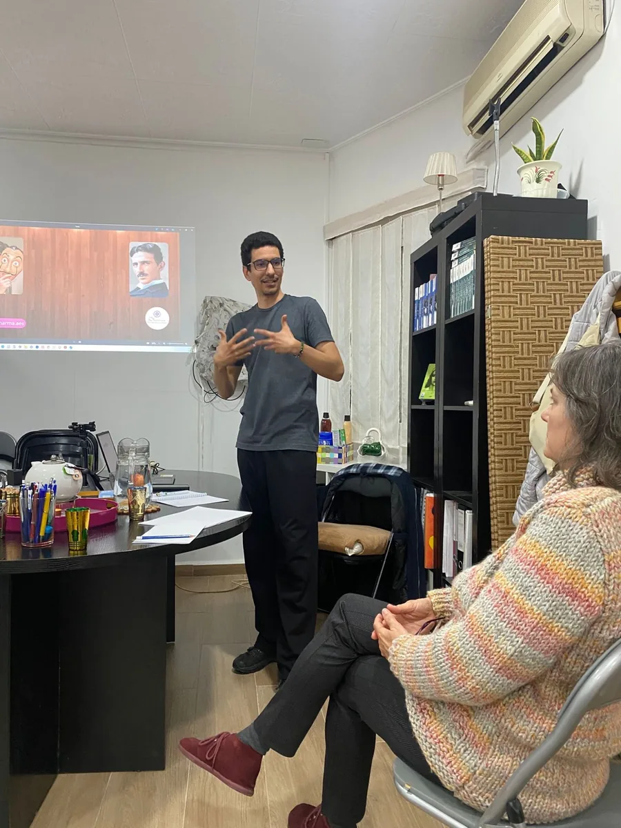 Ernesto Hoyos de pie explicando con las manos ante una participante durante un taller de oratoria en Alicante