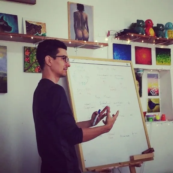 Ernesto Hoyos explicando frente a una pizarra en un taller